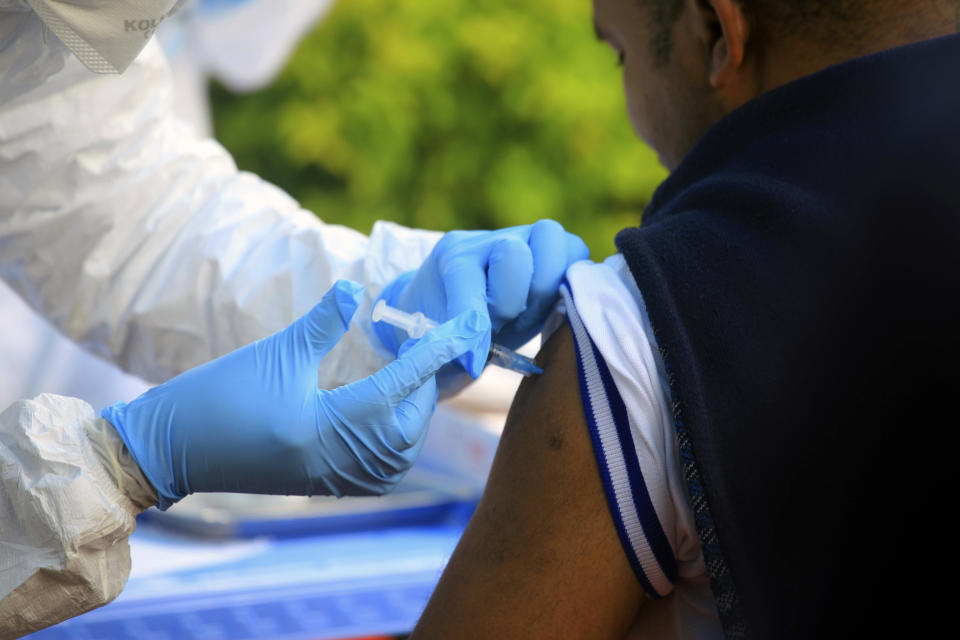 FILE - In this Aug. 8, 2018, file photo, a healthcare worker from the World Health Organization gives an Ebola vaccination to a front line aid worker in Mangina, Democratic Republic of Congo. One-fourth of the people interviewed in eastern Congo last year believed Ebola wasn't real, according to a new study released Wednesday, underscoring the enormous challenges health care workers are now facing. (AP Photo/Al-hadji Kudra Maliro, File)