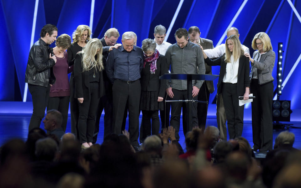 FILE - In this Tuesday, April 10, 2018 file photo, Willow Creek Community Church Senior Pastor Bill Hybels, sixth from left, and other church leaders pray before the congregation in South Barrington, Ill., where Hybels announced his early retirement effective immediately, amid a cloud of misconduct allegations involving women in his congregation. The announcement was made during a special meeting at the church, one of the nation's largest evangelical churches, which Hybels founded. (Mark Black/Daily Herald via AP)