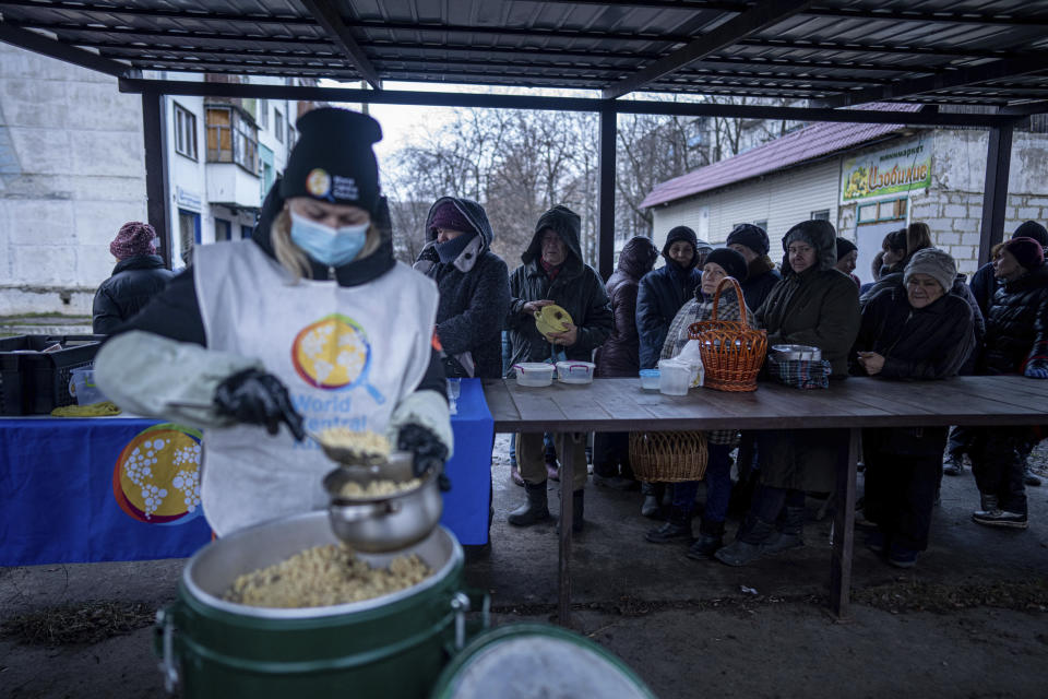 Local residents wait to receive a hot meal from volunteers of "World Central Kitchen", after living without electricity for more than four months in Kupiansk, Kharkiv region, Ukraine, Wednesday, Dec. 28, 2022. (AP Photo/Evgeniy Maloletka)