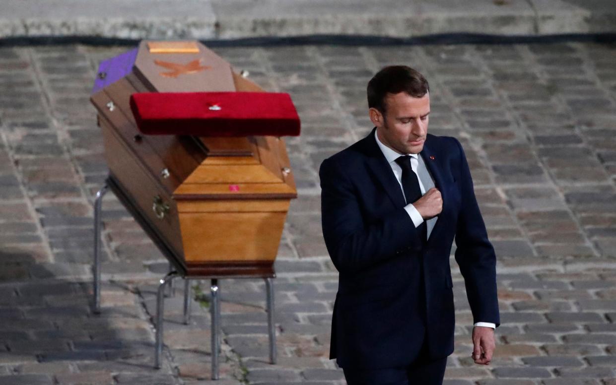 Emmanuel Macron leaves after paying his respects by the coffin of slain teacher Samuel Paty