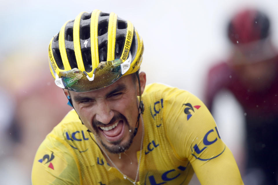 France's Julian Alaphilippe wearing the overall leader's yellow jersey crosses the finish line during the fifteenth stage of the Tour de France cycling race over 185 kilometers (114,95 miles) with start in Limoux and finish in Prat d'Albis, France, Sunday, July 21, 2019. (AP Photo/Christophe Ena)