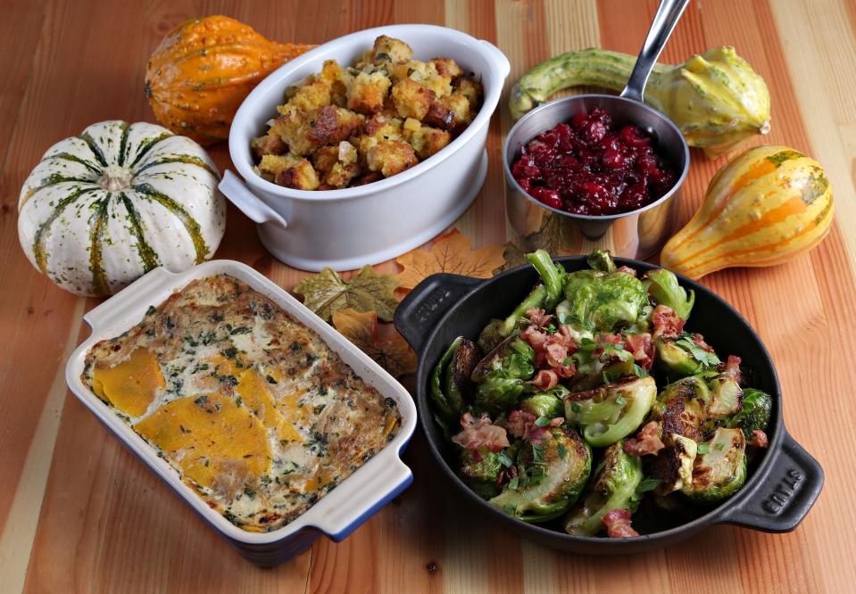 Thanksgiving potluck spread (clockwise from upper right): orange cranberry sauce, brussels sprouts with pancetta; butternut squash gratin; and cornbread stuffing with dried fruit.