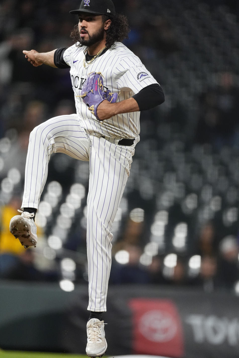 Colorado Rockies relief pitcher Justin Lawrence jumps after delivering a pitch to San Diego Padres' Jake Cronenworth during the ninth inning of a baseball game Tuesday, April 23, 2024, in Denver. (AP Photo/David Zalubowski)