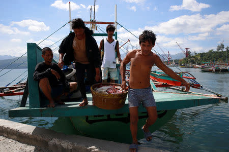 Fishermen, who has just returned from fishing in disputed Scarborough shoal, unload fish from a boat in Subic, Zambales in the Philippines, November 1, 2016. REUTERS/Erik De Castro