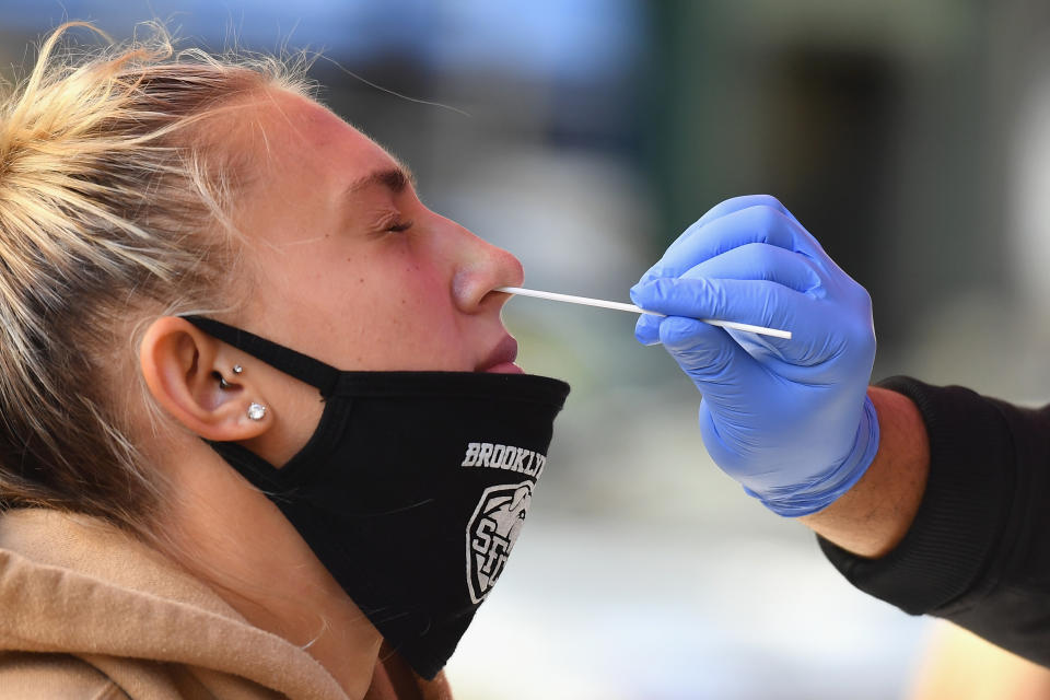 A medical worker takes a nasal swab sample from a student to test for COVID-19 at the Brooklyn Health Medical Alliance urgent care pop up testing site as infection rates spike on October 8, 2020 in New York City. - New York's governor announced earlier in the week tough new restrictions in several areas recording high infection rates to try to ward off a second coronavirus wave. (Photo by Angela Weiss / AFP) (Photo by ANGELA WEISS/AFP via Getty Images)