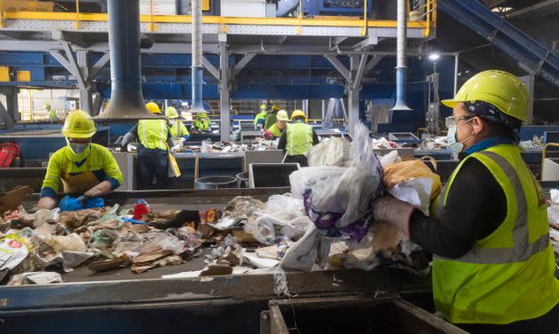 Workers remove non-recyclable plastics from cardboard at Republic Services in Anaheim, California, on April 15, 2021. (Photo: MediaNews Group/Orange County Register via Getty Images via Getty Images)