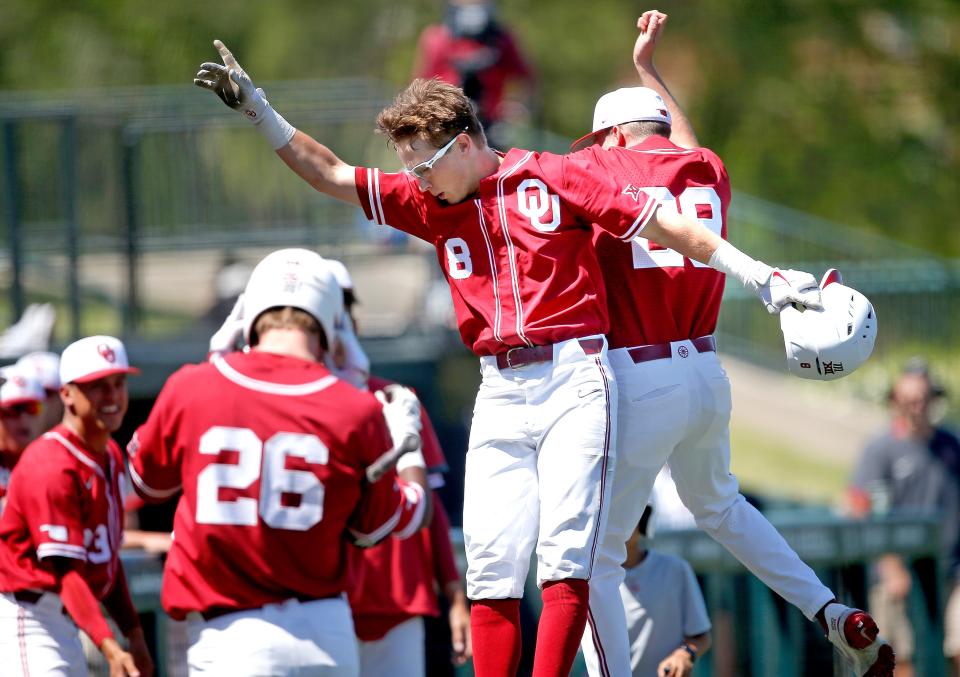 OU's John Spikerman (8) celebrates a run with Jett Lodes (29) in the third inning of a 22-10 win against Kansas State on Saturday in Norman.
