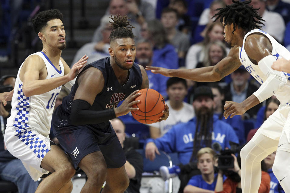 Fairleigh Dickinson's Elyjah Williams, center, looks for an opening between Kentucky's Johnny Juzang, left, and Keion Brooks Jr. during the second half of an NCAA college basketball game in Lexington, Ky., Saturday, Dec. 7, 2019. (AP Photo/James Crisp)