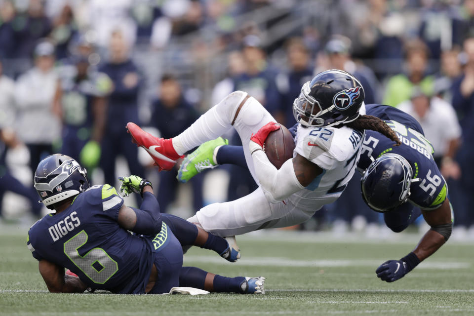 Tennessee Titans running back Derrick Henry (22) is tackled by linebacker Jordyn Brooks (56) and strong safety Quandre Diggs (6) during the second half of an NFL football game, Sunday, Sept. 19, 2021, in Seattle. The Titans won 33-30 in overtime. (AP Photo/John Froschauer)