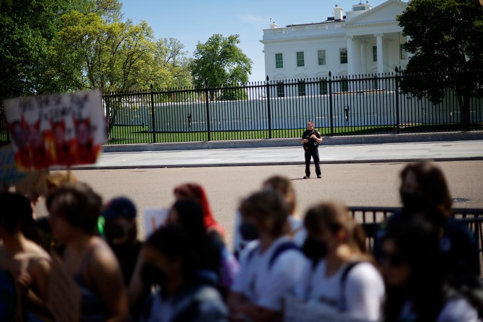 A U.S. Secret Service Uniform Division officer keeps an eye on young climate activists as they rally in Lafayette Park across from the White House on Earth Day on April 22.