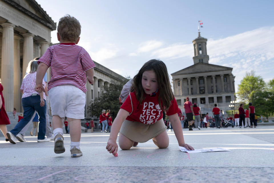 Mabel Weiss draws on the floor of Legislative Plaza during a demonstration for gun control legislation Tuesday, April 18, 2023, in Nashville, Tenn. Participants created a human chain spreading from Monroe Carell Jr. Children's Hospital at Vanderbilt, where victims of The Covenant School shooting were taken on March 27, to the Tennessee State Capitol. (AP Photo/George Walker IV)