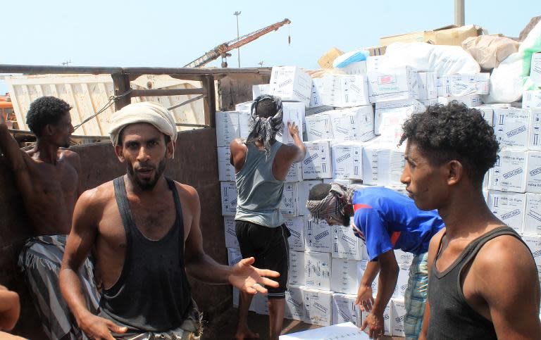 Yemeni workers unload medical aid boxes from a boat carrying 460 tonnes of Emirati relief aid that docked in the port of the city of Aden, on May 24, 2015