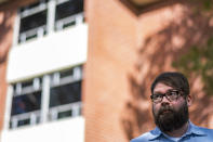 Chris Lambert, a musician and recording engineer, poses Thursday, April 15, 2021, in front of Muir Hall dormitory at California Polytechnic University in San Luis Obispo, Calif. Lambert started a podcast to document the 1996 disappearance of Kristin Smart, who was a college student at Cal Poly and lived in Muir Hall when she disappeared. On Tuesday, April 13, 2021, the San Luis Obispo County sheriff announced arrests in the 25-year-old case, crediting Lambert with helping bring in witnesses that propelled the case forward. (AP Photo/Nic Coury)