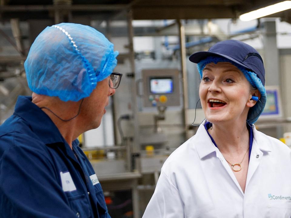 British Foreign Secretary and Conservative leadership candidate Liz Truss speaks with a worker as she attends a Conservative Party leadership campaign event at Condimentum Ltd at the Food Enterprise Park on August 25, 2022 in Norwich, England.