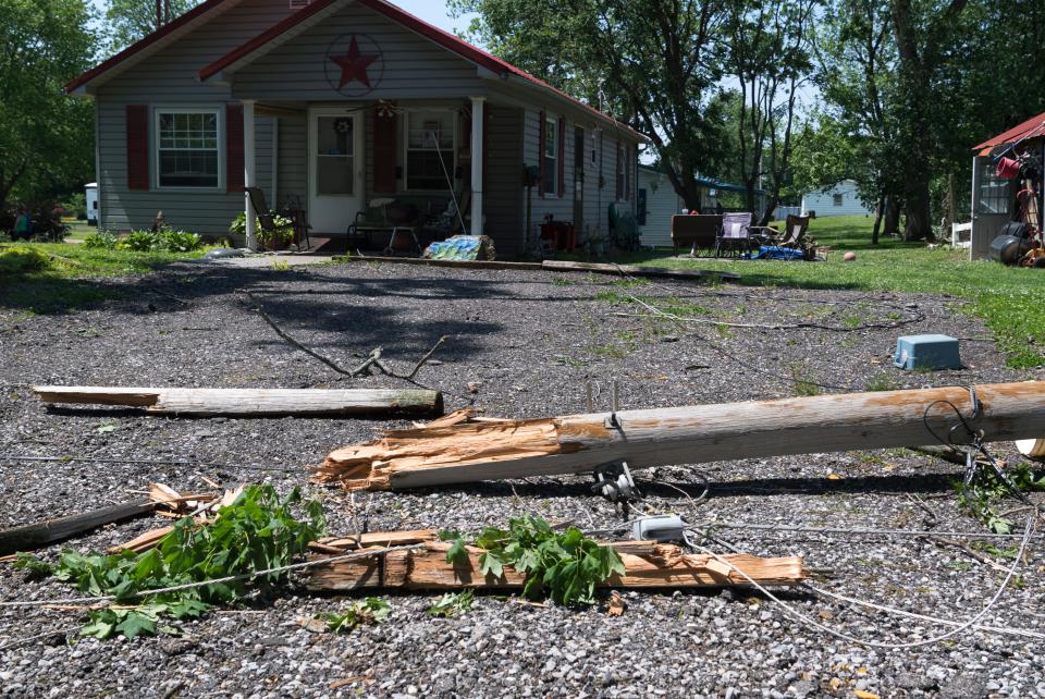 A split utility pole lays on the ground  in the Village of Keensburg, Ill., Friday, May 20, 2022. Heavy storm winds came through the area Thursday night causing significant damage. 