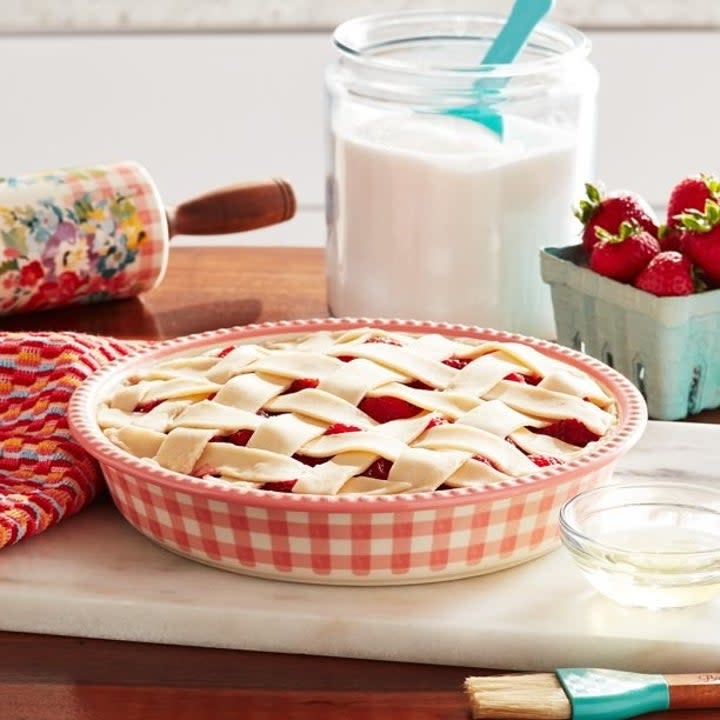 The plaid print dish holding an unbaked fruit pie