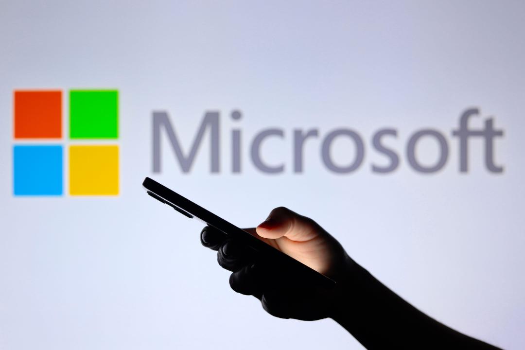 Paraguay. 30th July, 2024. In this photo illustration, the Microsoft Corporation logo seen in the background with a silhouette hand holding a smartphone. (Photo by Jaque Silva/SOPA Images/Sipa USA) *** Strictly for editorial news purposes only *** Credit: Sipa US/Alamy Live News