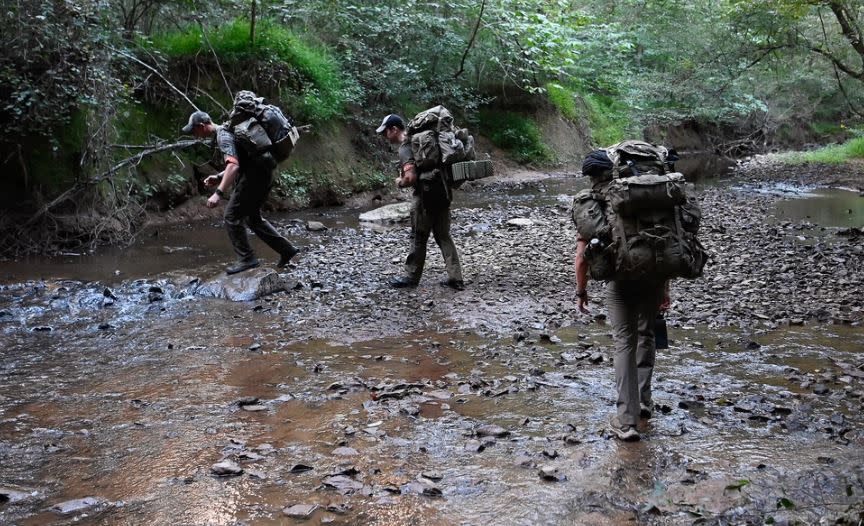 Special Forces candidates assigned to the U.S. Army John F. Kennedy Special Warfare Center and School walk through a small stream during the final phase of field training known as Robin Sage near Pittsboro, North Carolina, Sept. 16, 2023. (U.S. Army photo by K. Kassens)