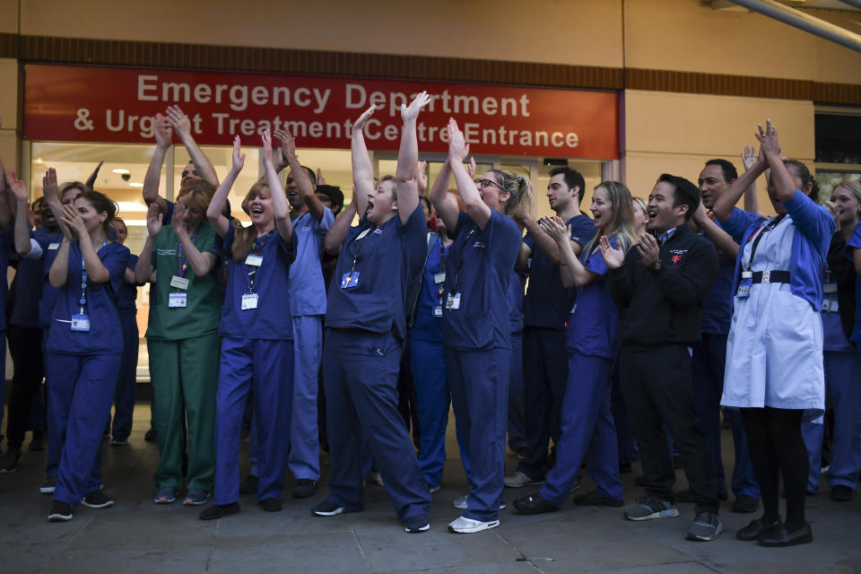 NHS staff applaud outside the Chelsea and Westminster Hospital in London during the weekly "Clap for our Carers", Thursday, April 16, 2020. The applause takes place across Britain every Thursday at 8pm local time to show appreciation for healthcare workers, emergency services, armed services, delivery drivers, shop workers, teachers, waste collectors, manufacturers, postal workers, cleaners, vets, engineers and all those helping people with coronavirus and keeping the country functioning while most people stay at home in the lockdown. (AP Photo/Alberto Pezzali)