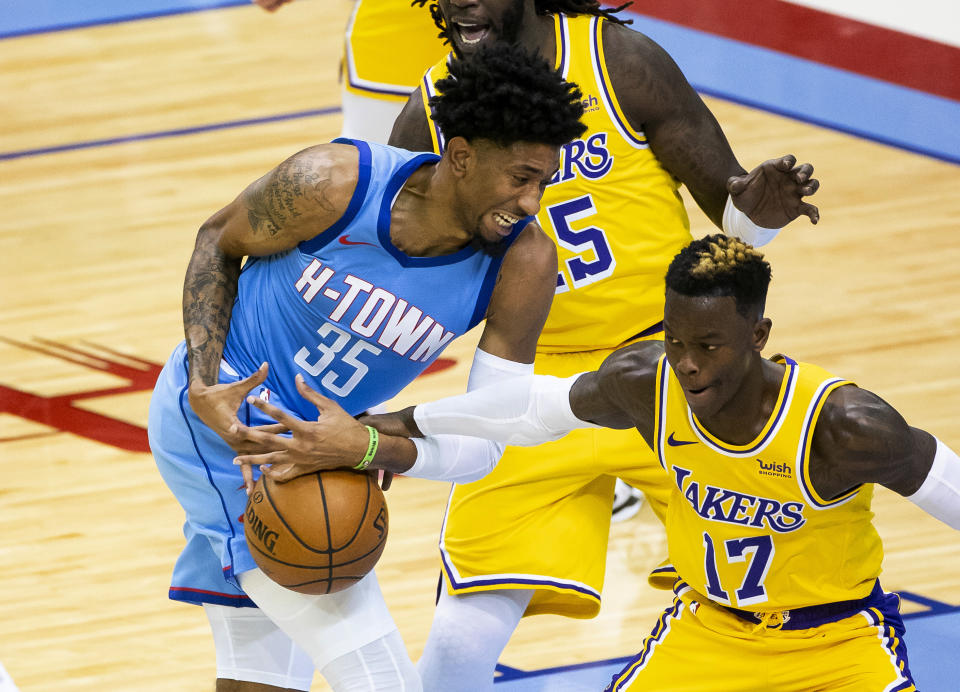 Houston Rockets center Christian Wood (35) loses the ball as he is defended by Los Angeles Lakers guard Dennis Schroeder (17) during the first quarter of an NBA basketball game Tuesday, Jan. 12, 2021, in Houston. (Mark Mulligan/Houston Chronicle via AP)