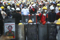 Anti-coup protesters wearing protective gear take positions as police gather in Yangon, Myanmar, Friday, March 5, 2021. Myanmar's military, fresh off a coup, has killed scores of unarmed protesters. It's jailed reporters, and anyone else capable of exposing the violence. The outside world has responded so far with tough words _ and little else. (AP Photo)