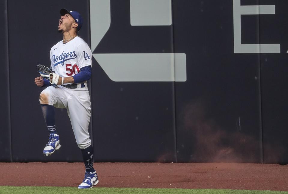 Dodgers right fielder Mookie Betts celebrates after making a leaping catch on a drive by Atlanta's Marcell Ozuna.