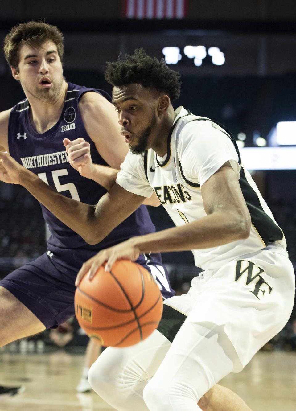 Wake Forest \ forward Isaiah Mucius (1) dribbles around the defense of Northwestern center Ryan Young (15) in the first half of an NCAA college basketball game on Tuesday, Nov. 30, 2021, at the Joel Coliseum in Winston-Salem, N.C. (Allison Lee Isley/The Winston-Salem Journal via AP)