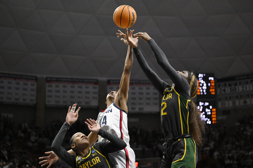 UConn's Aubrey Griffin, center, grabs a rebound over Baylor's Kyla Abraham, right, in the second half of a second-round college basketball game in the NCAA Tournament, Monday, March 20, 2023, in Storrs, Conn. (AP Photo/Jessica Hill)