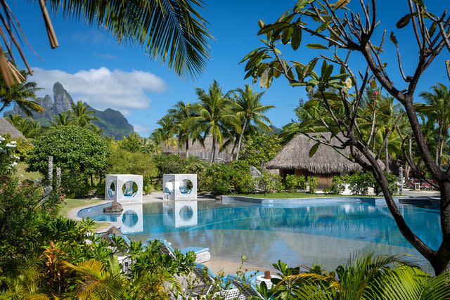 <p>John Kincaid/Courtesy of The St. Regis Bora Bora</p> The main pool at The St. Regis Bora Bora, with contemporary cubic cabanas.