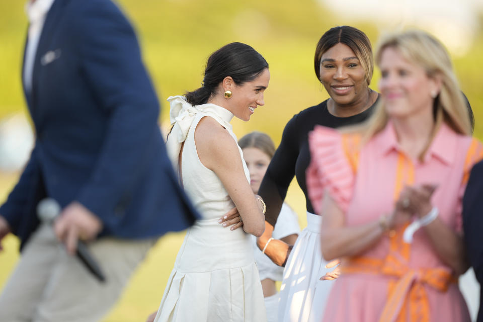Meghan Markle, Duchess of Sussex, center, speaks with Serena Williams, and other guests, at the 2024 Royal Salute Polo Challenge to Benefit Sentebale, in Wellington, Fla., April 12, 2024. (AP Photo/Rebecca Blackwell)