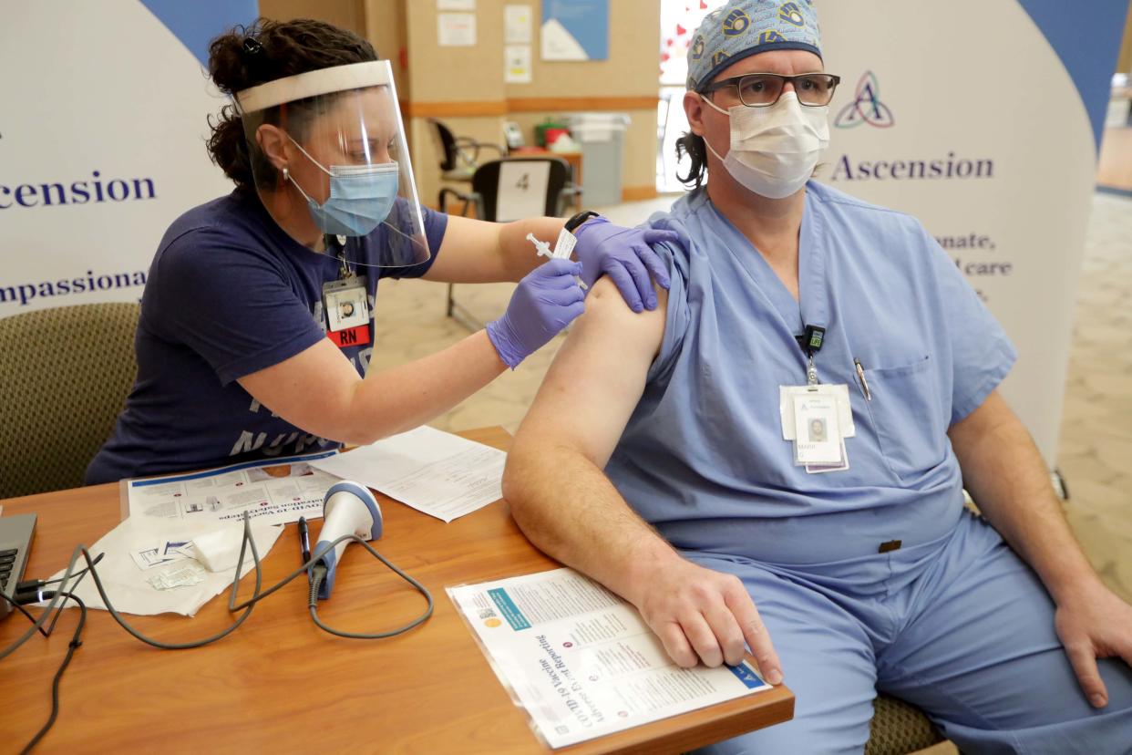 Dr. Mark Gustafson, right, an Ascension Wisconsin respiratory therapist doctor, receives the COVID-19 vaccine from ER nurse Stephanie Fidlin, at Ascension SE Wisconsin Hospital in Franklin on Wednesday.