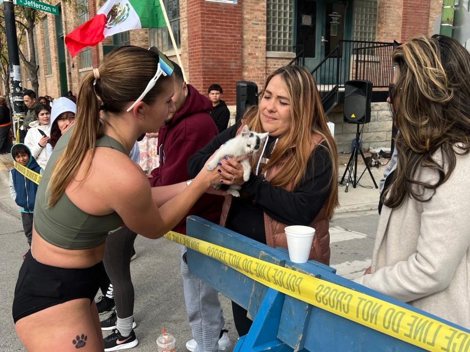 Sarah Bohan (left) hands the kitten to a kind spectator.