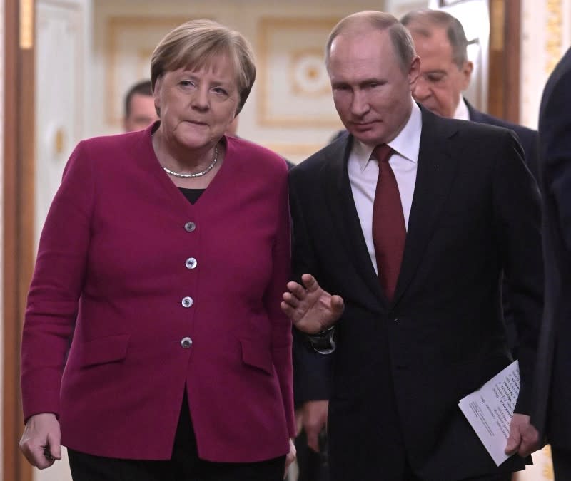 Russian President Vladimir Putin and German Chancellor Angela Merkel arrive for a joint news conference in the Kremlin in Moscow