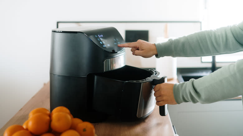 Person using basket air fryer