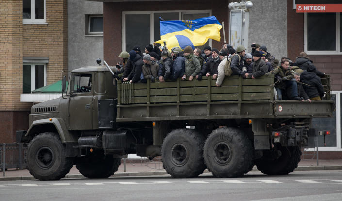 Protesters ride atop of what appears to be a military truck, in central Kiev, Ukraine, Saturday, Feb. 22, 2014. Protesters in the Ukrainian capital claimed full control of the city Saturday following the signing of a Western-brokered peace deal aimed at ending the nation's three-month political crisis. The nation's embattled president, Viktor Yanukovych, reportedly had fled the capital for his support base in Ukraine's Russia-leaning east. (AP Photo/Darko Bandic)