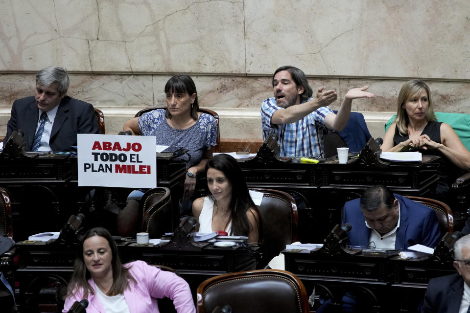 Un cartel que dice en español "Abajo todo el plan Milei" cuelga junto a legisladores de la oposición, mientras habla Nicolás del Caño antes del inicio de un debate sobre un proyecto de ley promovido por el presidente argentino Javier Milei en el Congreso en Buenos Aires, Argentina, el miércoles. 31 de enero de 2024. (AP Foto/Natacha Pisarenko)