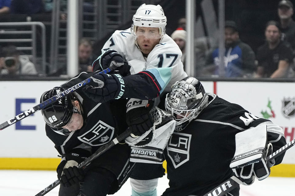 Seattle Kraken center Jaden Schwartz, center, tries to get past Los Angeles Kings center Rasmus Kupari, left, and goaltender Cal Petersen as he goes after the puck during the third period of an NHL hockey game Tuesday, Nov. 29, 2022, in Los Angeles. (AP Photo/Mark J. Terrill)