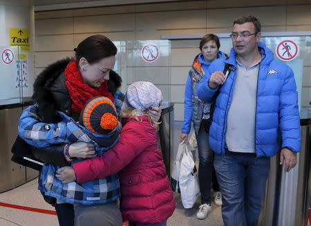 A mother embraces her children, who are passengers of a flight from the Egyptian resort of Hurghada shortly after their arrival, at Domodedovo airport outside Moscow, Russia, November 7, 2015. REUTERS/Maxim Shemetov