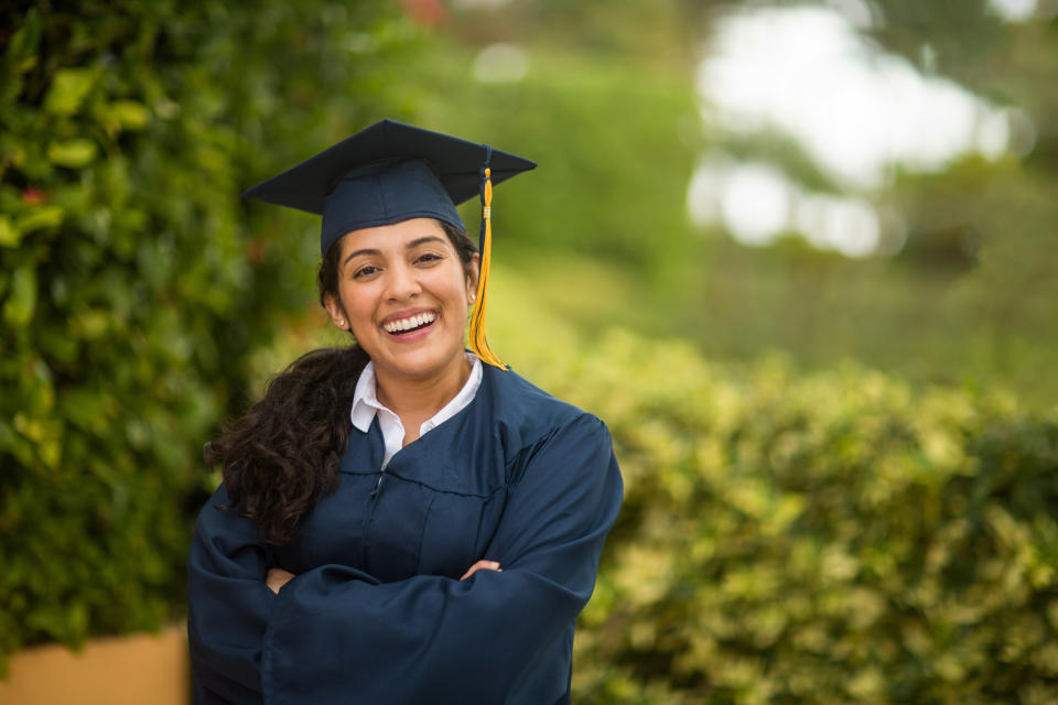 Happy young Hispanic woman graduating.