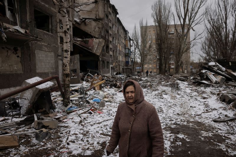 A woman walks past apartment blocks that were destroyed in a Russian missile strike in Selydove near Avdiivka