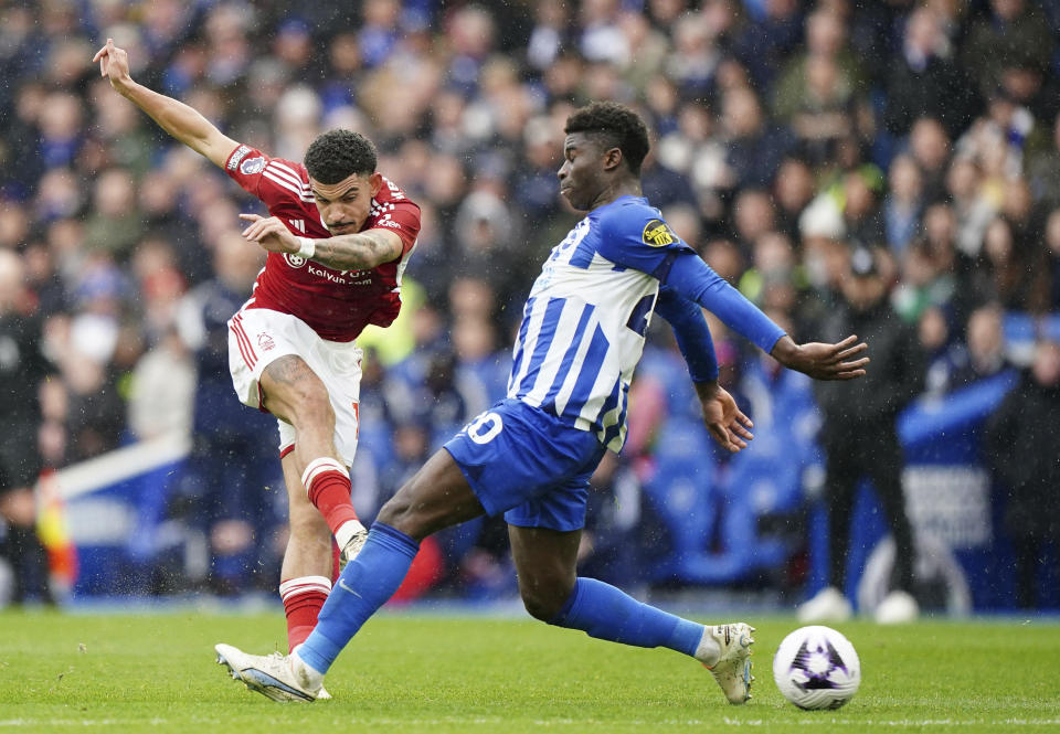 Nottingham Forest's Morgan Gibbs-White, left, attempts a shot on goal during the English Premier League soccer match between Brighton and Hove Albion and Nottingham Forest at the American Express Stadium, Brighton, England, Sunday March 10, 2024. (Zac Goodwin/PA via AP)