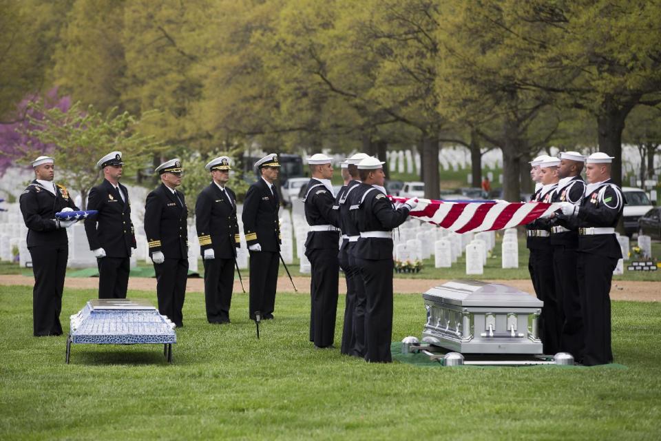 A U.S. Navy honor guard holds a flag over the casket of U.S. Navy Petty Officer 2nd Class Mark Mayo, of Hagerstown, Md., during a burial service at Arlington National Cemetery in Arlington, Va., Friday, April 25, 2014. Mayo was killed aboard the USS Mahan at Naval Station Norfolk, Va., after he dove in front of another sailor to protect her from a civilian truck driver who had seized her gun. Mayo was awarded the Navy Marine Corps Medal, the highest non-combatant decoration for heroism by a sailor or Marine. (AP Photo/ Evan Vucci)