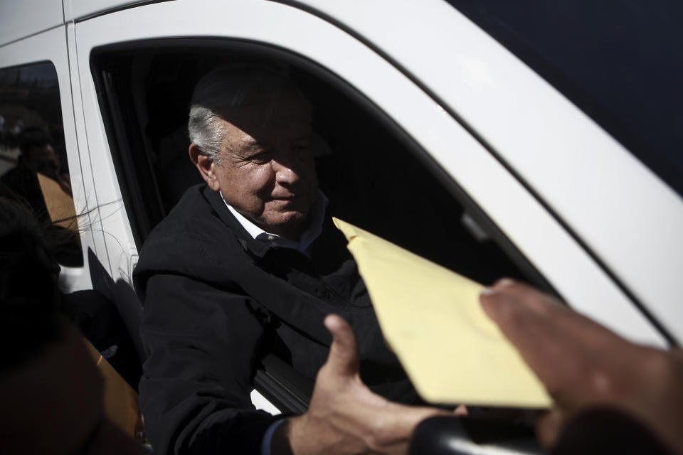 Mexican President Andres Lopez Obrador receives an envelope at the end of a meeting at a public education institution during his visit to Ciudad Juarez, Mexico, Friday, March 31, 2023. Mexico’s president promised to visit hospitals treating the migrants injured in the recent fire at a dormitory at a detention center in Ciudad Juarez where more than three dozen migrants died. (AP Photo/Christian Chavez)