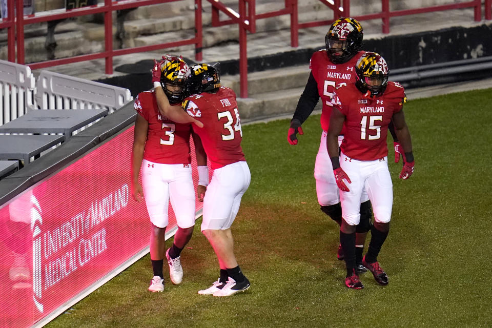 Maryland quarterback Taulia Tagovailoa (3) is congratulated by running back Jake Funk (34) after scoring a touchdown run against Minnesota during overtime of an NCAA college football game, Friday, Oct. 30, 2020, in College Park, Md. Maryland won 45-44 in overtime. (AP Photo/Julio Cortez)