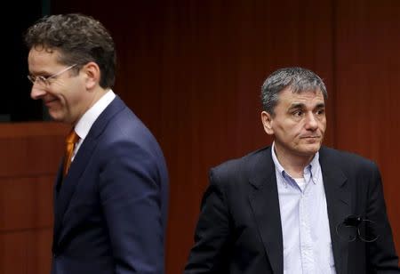 Greek Finance Minister Euclid Tsakalotos (R) walks past Dutch Finance Minister and Eurogroup President Jeroen Dijsselbloem during a eurozone finance ministers meeting in Brussels, Belgium, January 14, 2016. REUTERS/Francois Lenoir