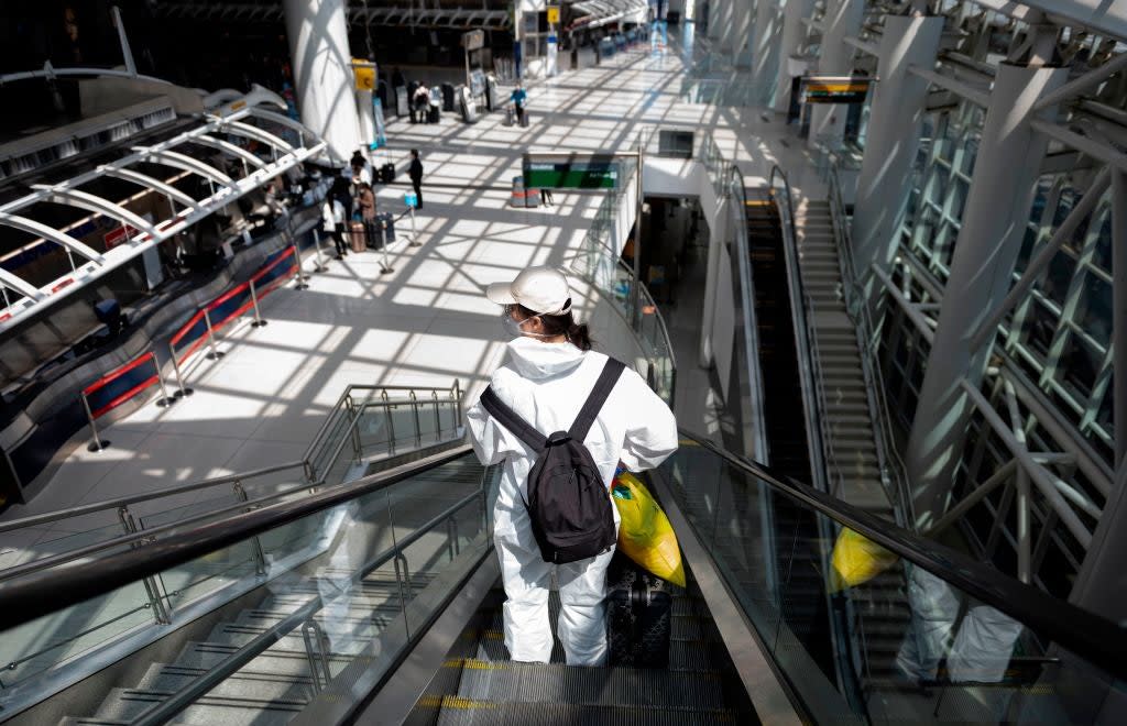 <p>A plane passenger travels through John F. Kennedy Airport in May</p> (AFP via Getty Images)