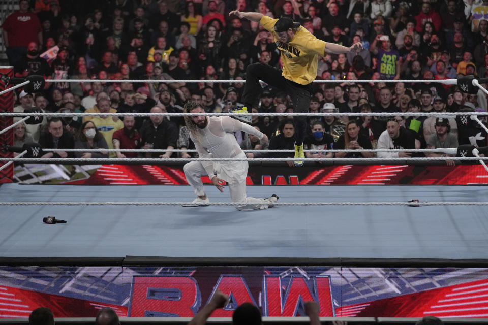 Wrestler Logan Paul, right, kicks Seth "Freakin" Rollins during the WWE Monday Night RAW event, Monday, March 6, 2023, in Boston. WWE’s WrestleMania arrives this weekend, Saturday, April 1, to a massive audience and vastly larger advertising revenue as it seeks to establish itself as a serious contender for major advertising bucks. (AP Photo/Charles Krupa)