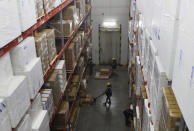 Workers move boxes inside Snowman Logistics, India's largest cold storage company in Taloja on the outskirts of Mumbai, India, Saturday, Oct. 17, 2020. The vaccine cold chain hurdle is just the latest disparity of the pandemic weighted against the poor, who more often live and work in crowded conditions that allow the virus to spread, have little access to medical oxygen vital to COVID-19 treatment, and whose health systems lack labs, supplies or technicians to carry out large-scale testing. (AP Photo/Rajanish Kakade)