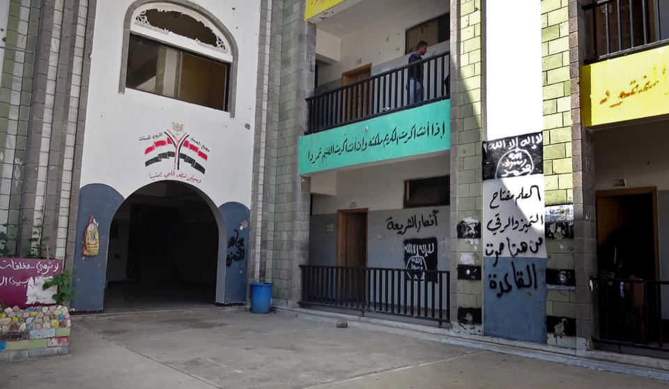 The black al-Qaida flag and the slogan in Arabic “al-Qaida passed here,” on the right wall, are sprayed on a damaged school that was turned into a religious court in the southern city of Taiz, Yemen, in this Oct. 16, 2017 photo. Coalition-backed militias have enlisted al-Qaida fighters to battle the Shiite rebels known as Houthis who have besieged Taiz for more than two years. (AP Photo)