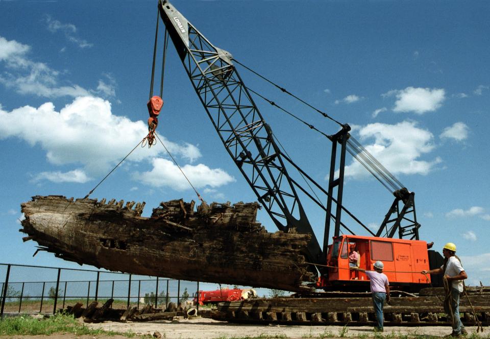 FILE - A crane lifts the remains of the Lottie Cooper in this early 1990s photo.  Its remains are on display today at Deland Park on Broughton Drive in Sheboygan, Wis. The 89-foot-long section is believed to be the longest section of a Great Lakes schooner on display anywhere.